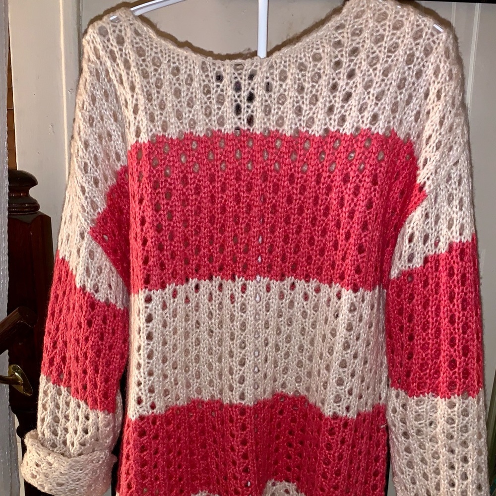 A ladies pink and white crocheted sweater